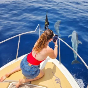 Pasajero pescando desde la proa de SeaPassion en alta mar.